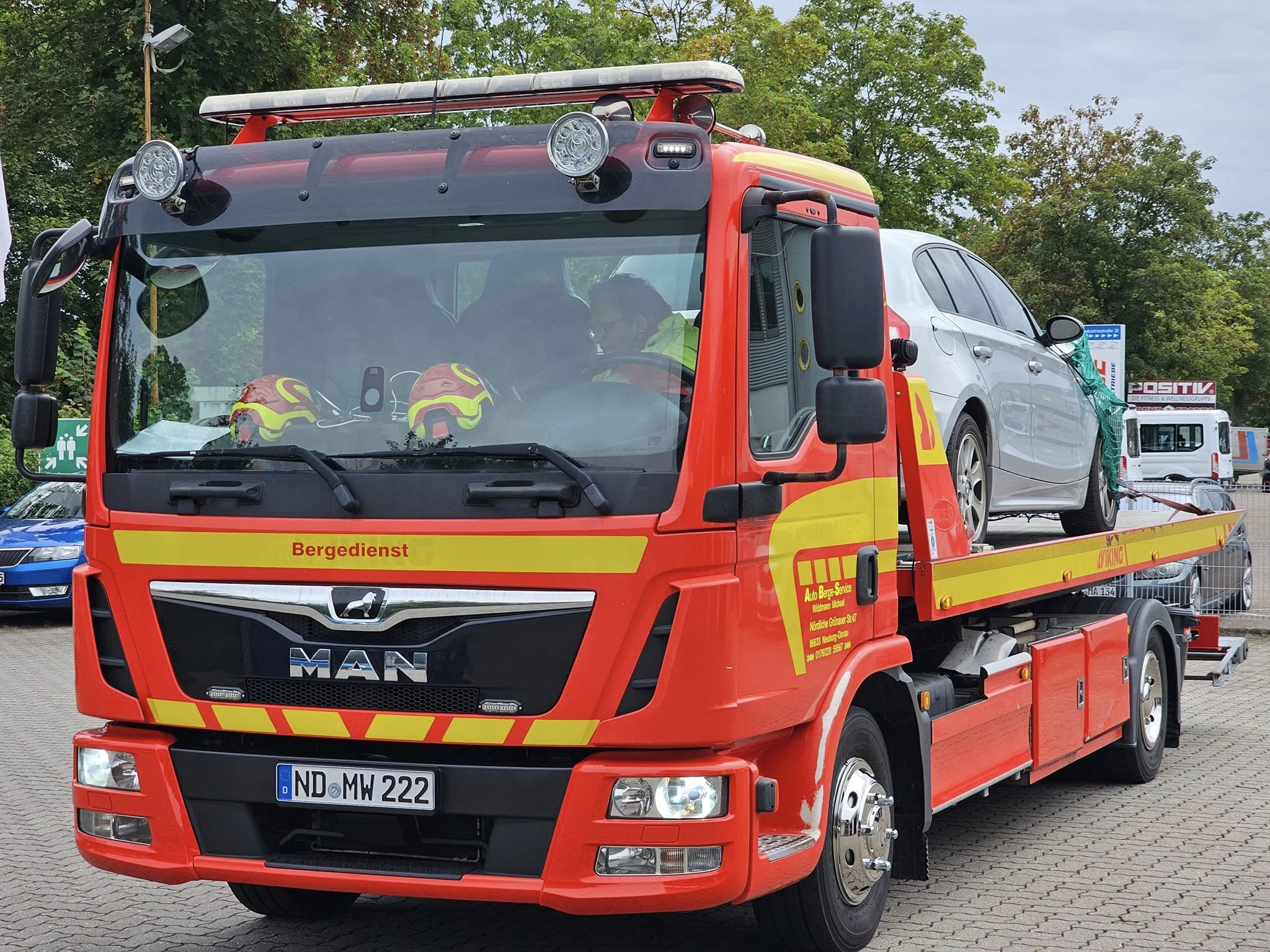 Roter MAN TGL Bergedienst mit Fahrzeug auf der Ladefläche